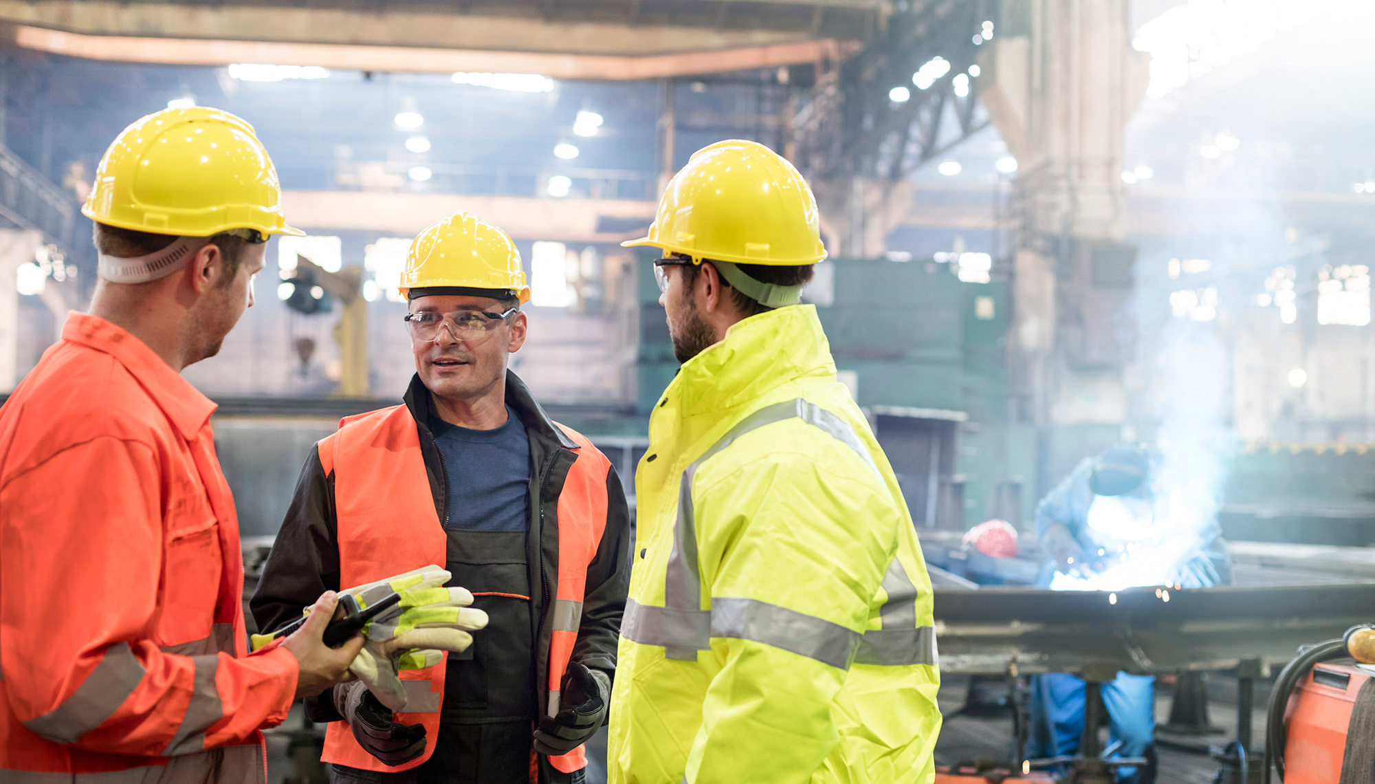 arbeidere i hardhats samles i arbeidsområdet